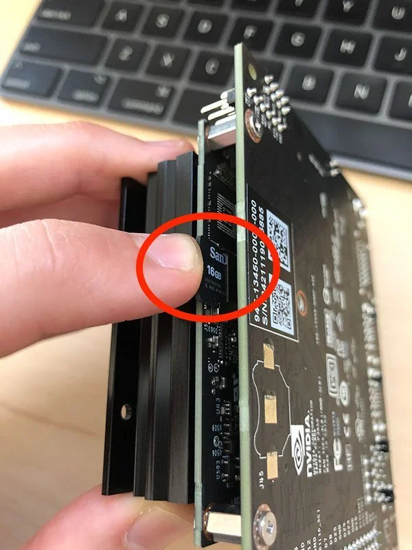 The microSD card slot under the Jetson Nano module, circled in red